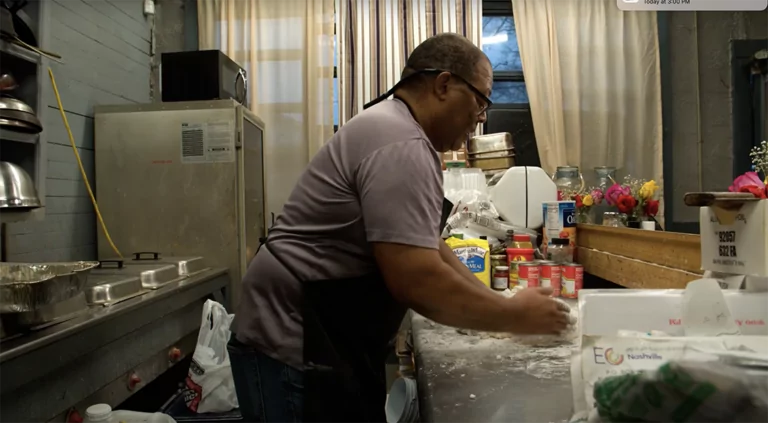 School cafeteria employee prepares food.
