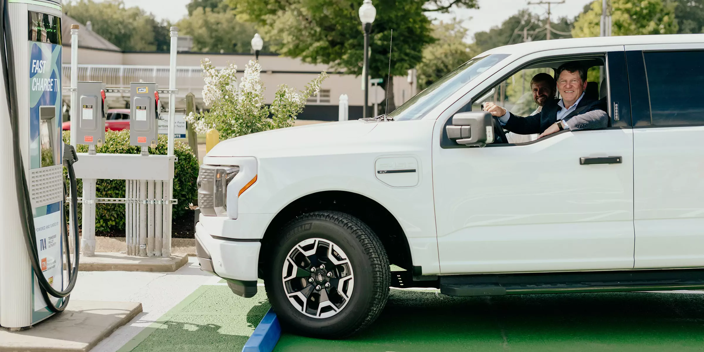 Man in electric vehicle at charging station