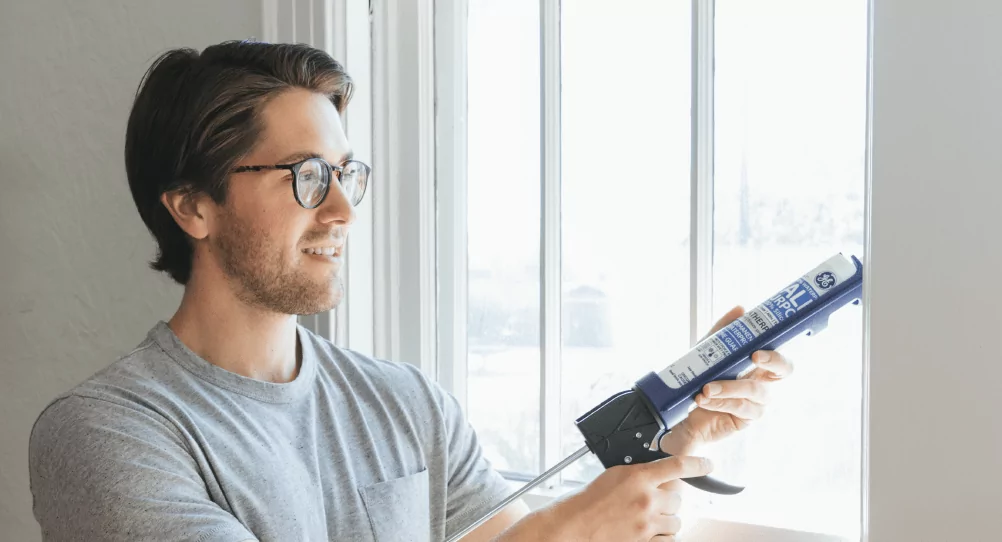 Man caulking window