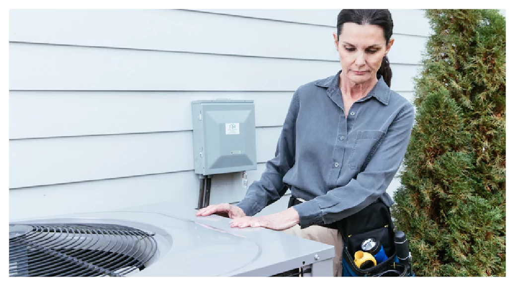 Member of the Quality Contractor Network inspecting a heat pump.