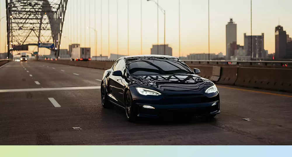An EV driving over a bridge.
