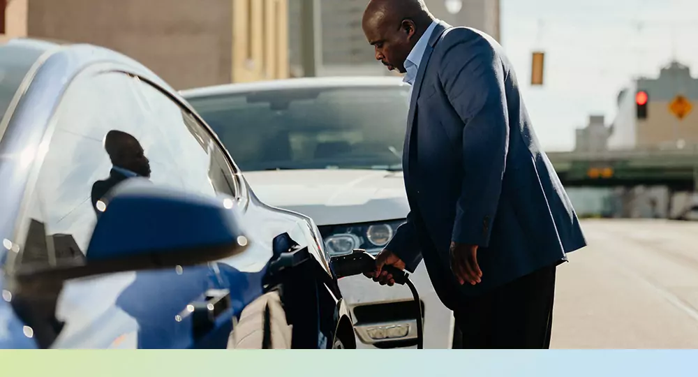 Man charging an electric vehicle.