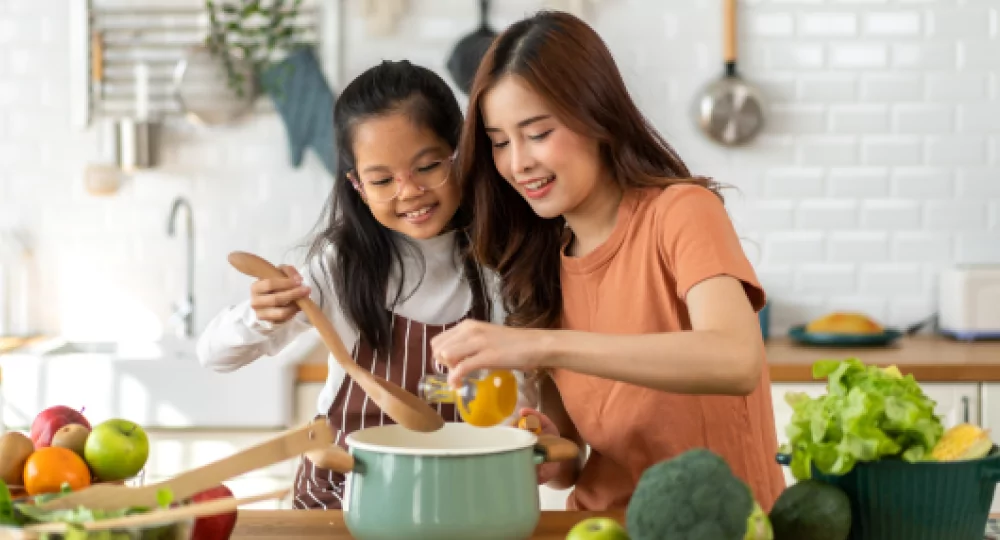 Two girls making soup.