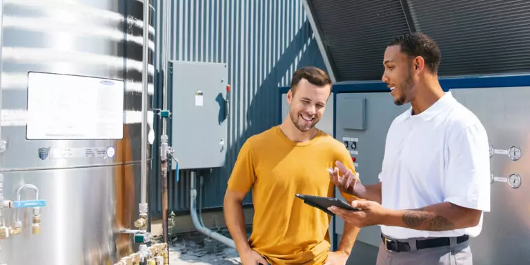 Two facility professionals discuss industrial equipment.