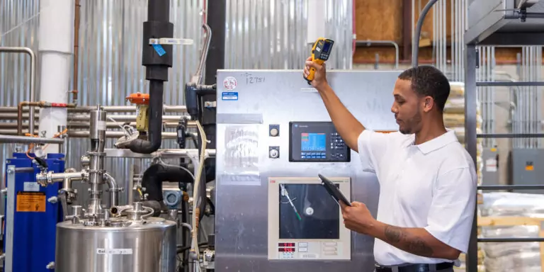 Worker inspects industrial production equipment.