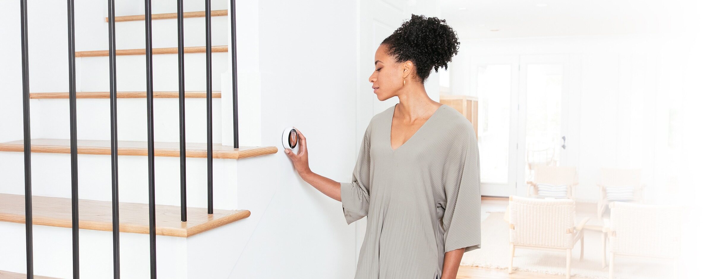 woman adjusting thermostat.