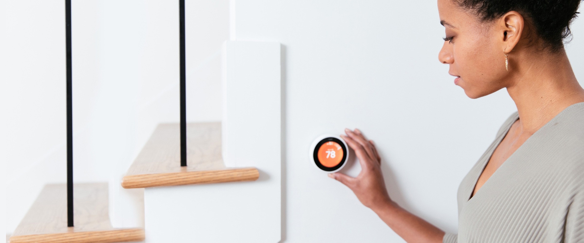 Woman adjusting thermostat