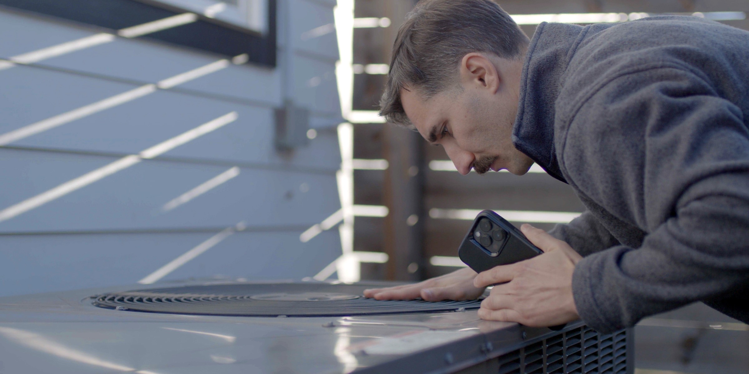 Man inspecting a traditional heat pump