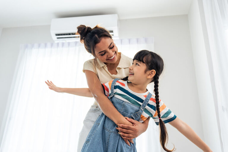 mom and daughter playing in front of a mini split head unit.