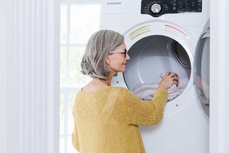 Woman taking towels out of an energy efficient dryer