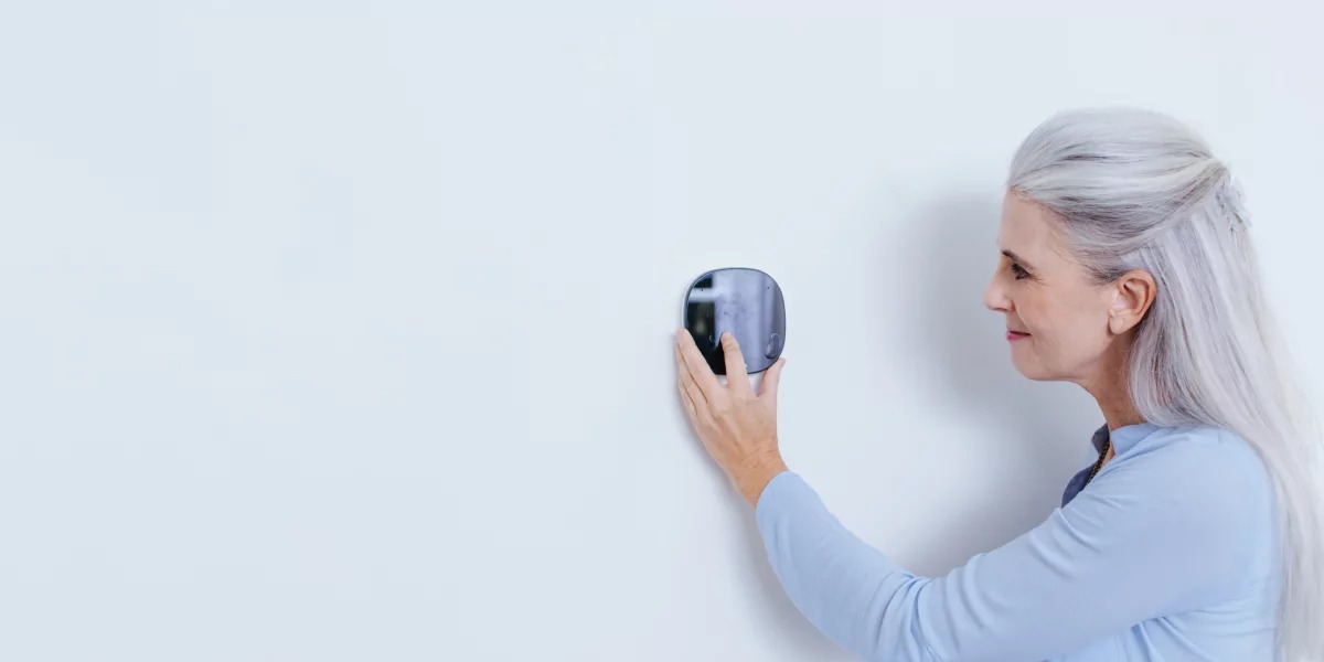 woman adjusting thermostat