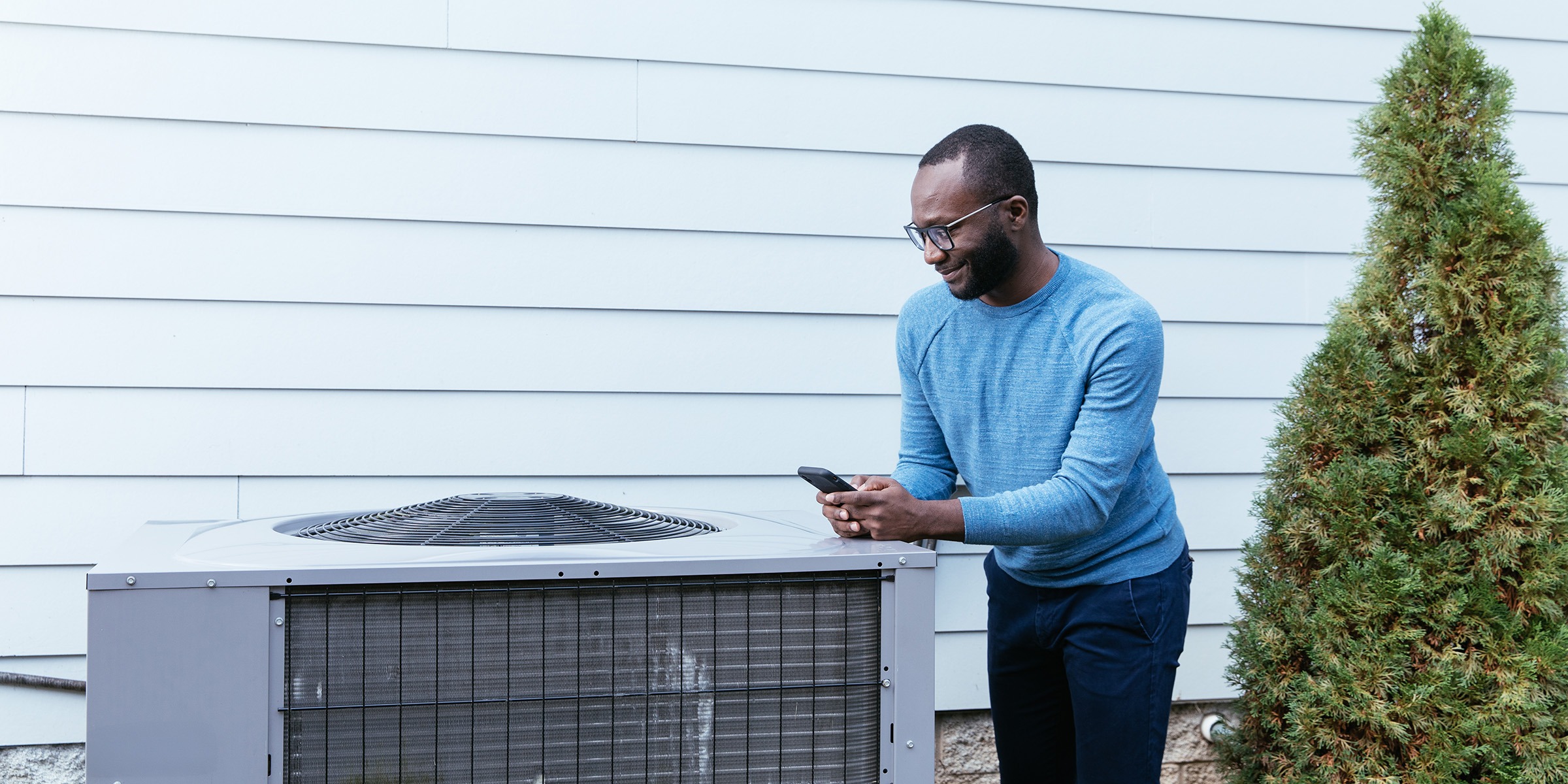 Man inspecting external heat pump system.
