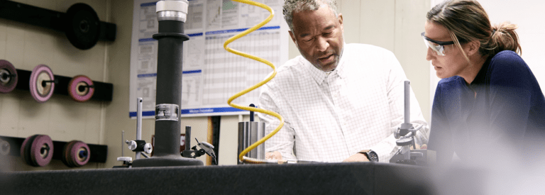 Two colleagues talking near compressed air equipment