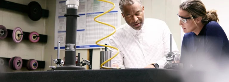 Two colleagues talking near compressed air equipment