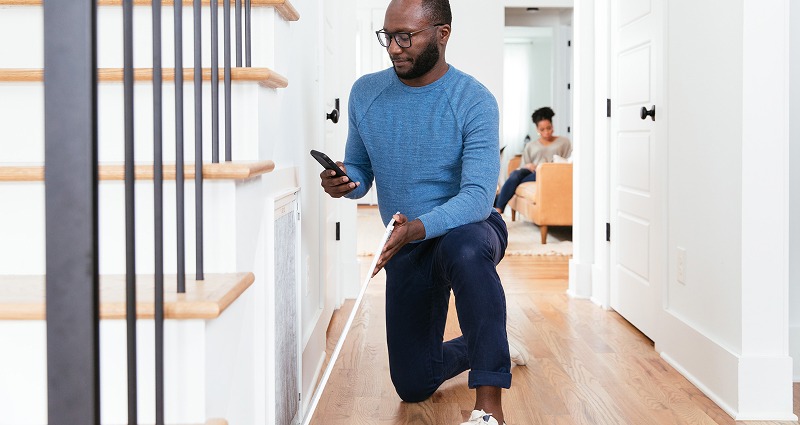 Man wearing a blue sweater, installing a new air filter. 