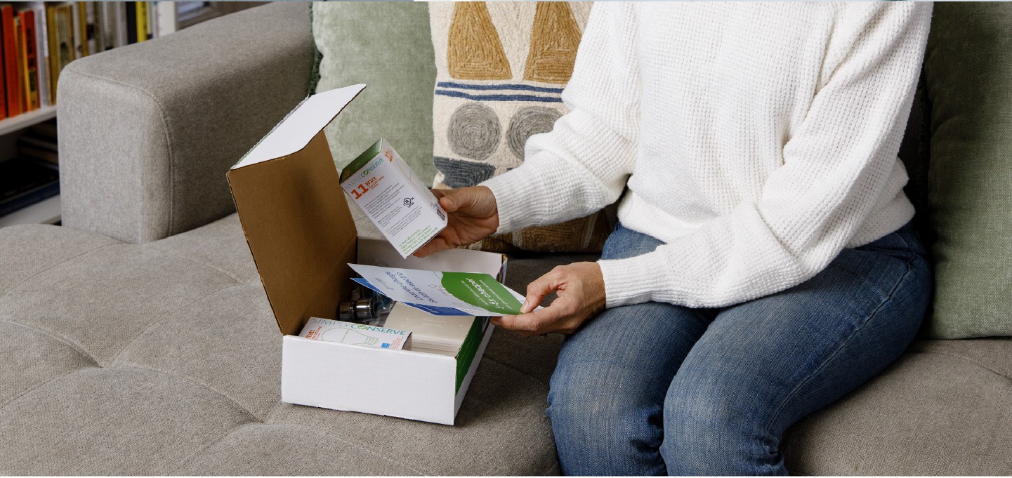 Homeowner opening a home energy-saving kit and reviewing instructions