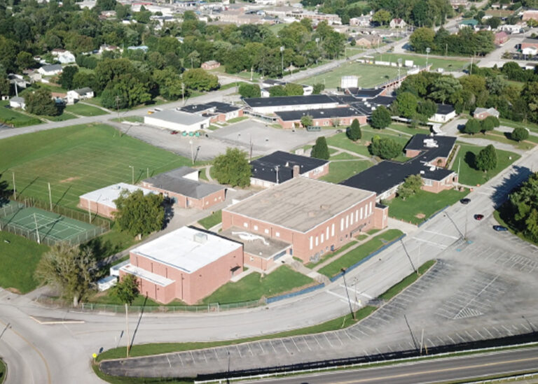 An aerial view of the Roane County High School campus featuring brick buildings, athletic fields, and parking lots.
