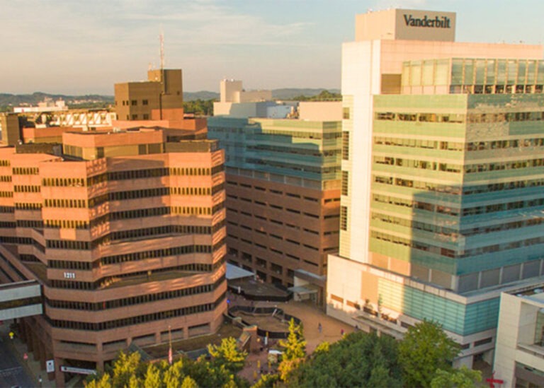 The multi-story brick and glass commercial facilities of the Vanderbilt campus complex under warm sunlight.
