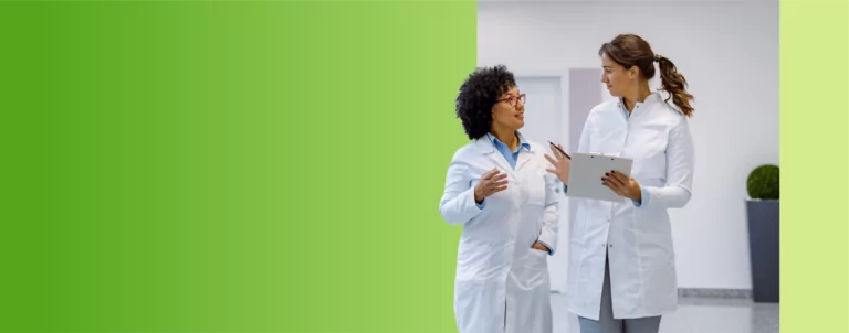 Two TVA Energy Experts in white coats collaborate on energy-saving strategies for community initiatives.