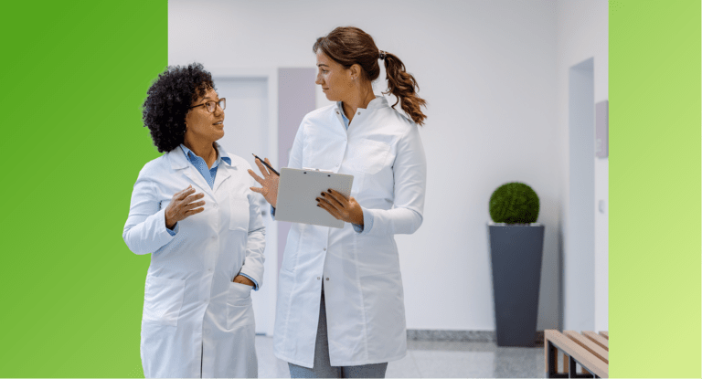 Two TVA Energy Experts in white coats collaborate on EnergyRight program strategies in a bright hallway.