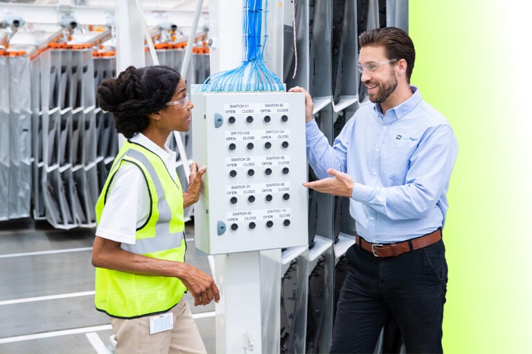 An EnergyRight specialist explains industrial energy management controls to a facility worker.