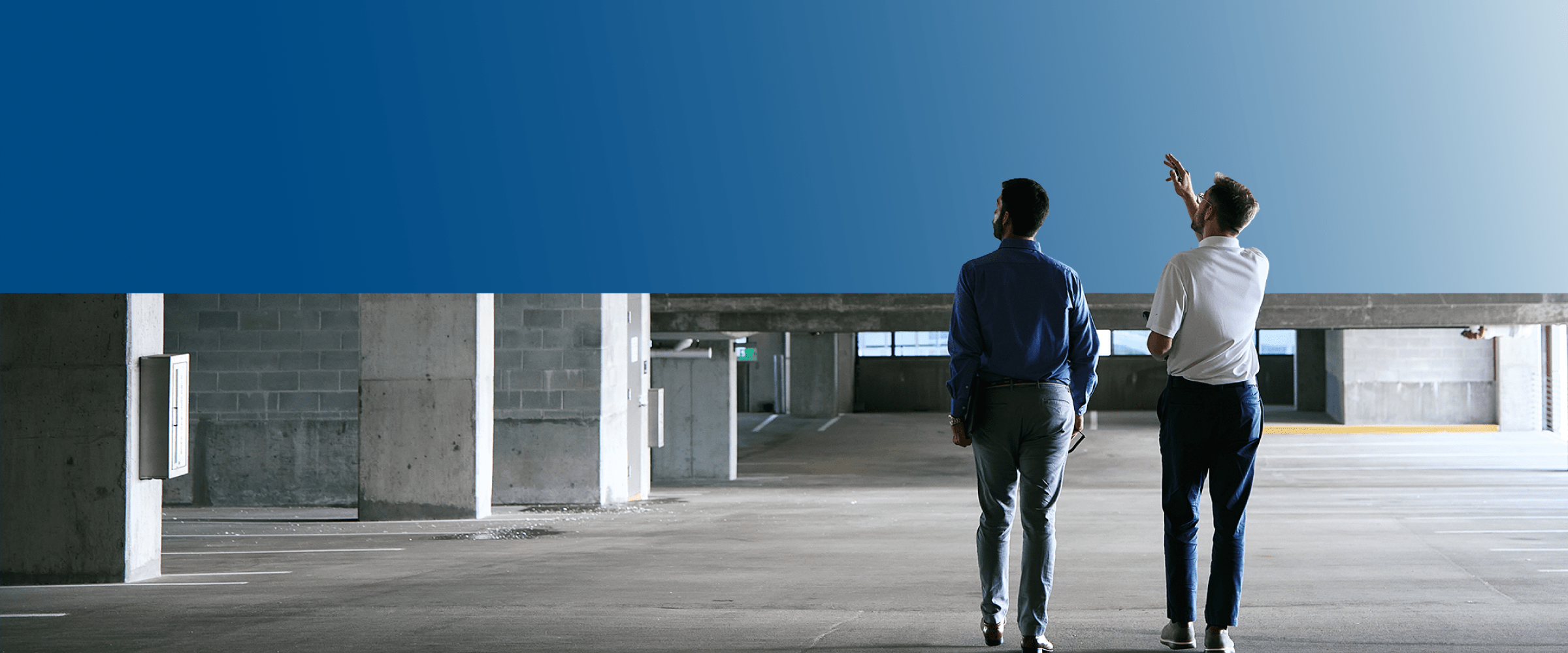 Two TVA Energy Experts assess a commercial building, discussing potential energy-efficient upgrades like LED lighting.