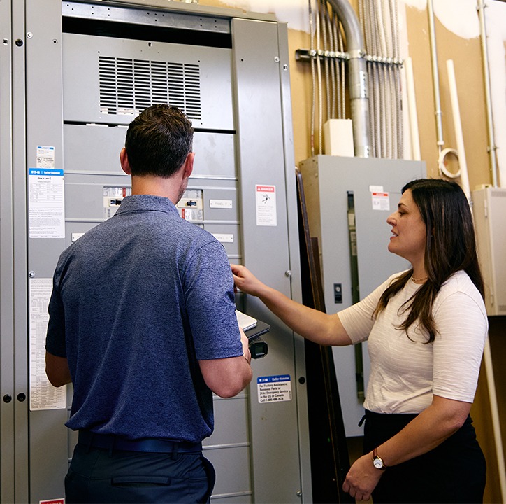 TVA Energy Experts performing an energy audit, examining a complex commercial electrical panel for efficiency opportunities.